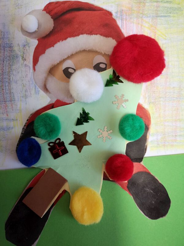 Zdjęcie przedstawia kartkę  do Mikołaja.Jest na niej Mikołaj trzymający drzewko świąteczne
